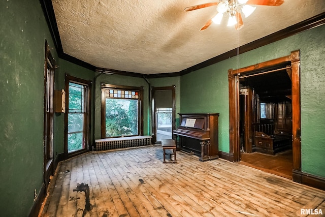 unfurnished room featuring radiator, a textured wall, wood-type flooring, and a textured ceiling