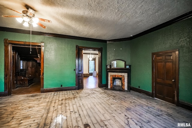 unfurnished living room with a fireplace with flush hearth, a textured wall, wood-type flooring, and ornamental molding