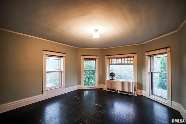 unfurnished room featuring radiator heating unit, a healthy amount of sunlight, dark wood-style flooring, and baseboards