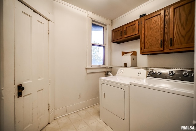 clothes washing area featuring baseboards, cabinet space, and independent washer and dryer