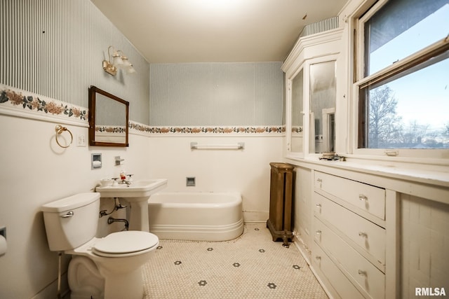 full bath with a garden tub, toilet, and wallpapered walls