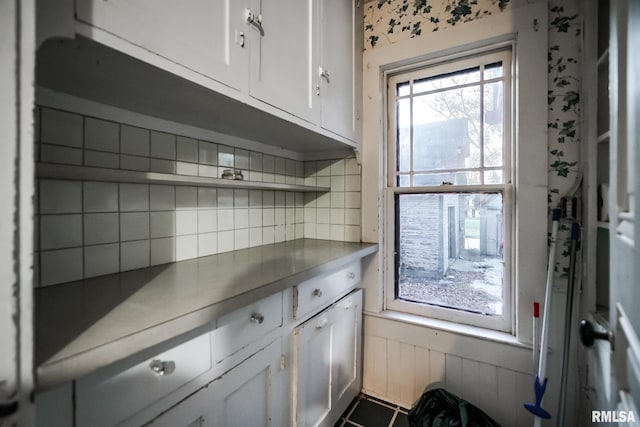 kitchen with open shelves, decorative backsplash, a wainscoted wall, and white cabinetry