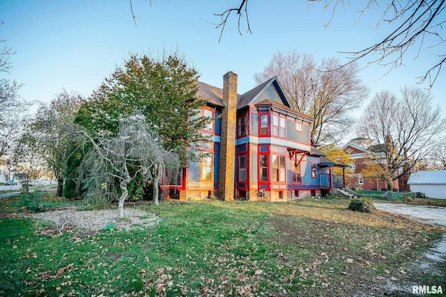 rear view of house with a yard and a chimney