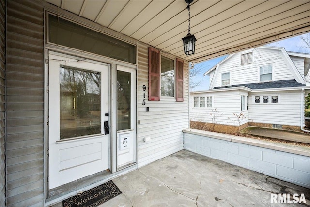 property entrance featuring covered porch and a gambrel roof