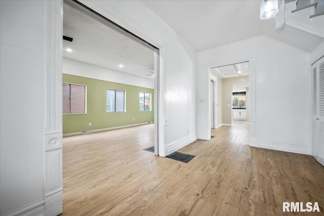 empty room with plenty of natural light, baseboards, visible vents, and wood finished floors