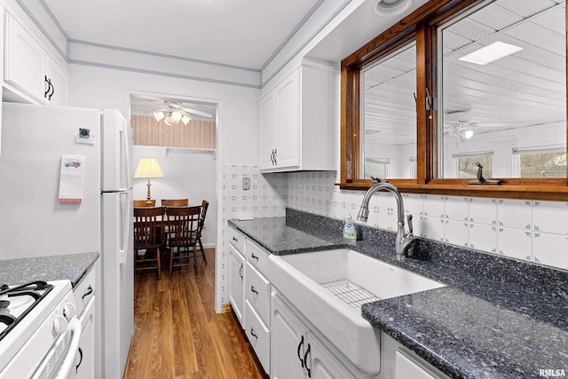 kitchen featuring a sink, light wood-style floors, white cabinetry, and ceiling fan