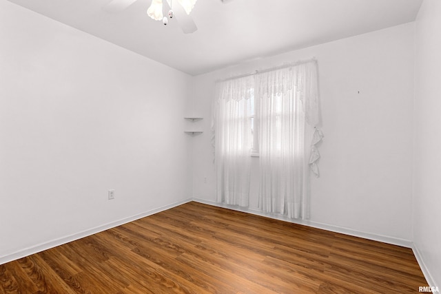 unfurnished room with a ceiling fan, wood finished floors, and baseboards