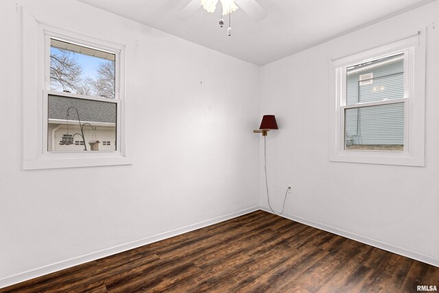 unfurnished room featuring dark wood finished floors, baseboards, and ceiling fan