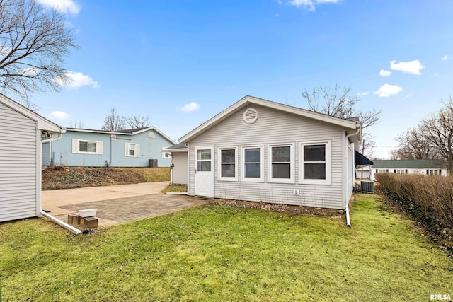 back of house featuring a patio area and a lawn