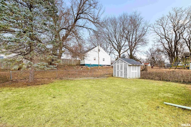 view of yard featuring a storage shed, an outbuilding, and fence private yard