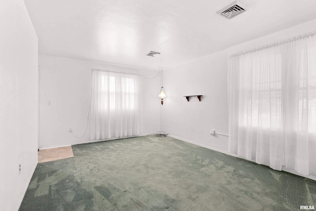 empty room featuring carpet flooring and visible vents