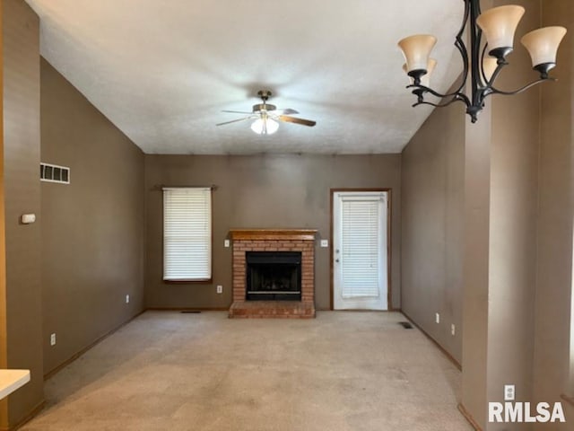 unfurnished living room with visible vents, light carpet, a fireplace, and a ceiling fan