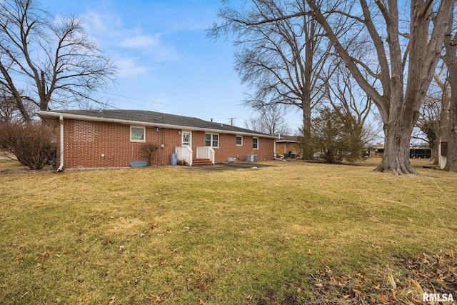 rear view of house with a yard and brick siding