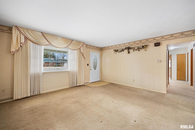 unfurnished room featuring wallpapered walls, baseboards, and carpet floors