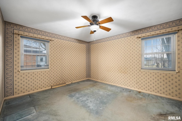 carpeted spare room featuring baseboards, ceiling fan, and wallpapered walls