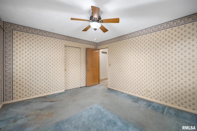 empty room with baseboards, ceiling fan, carpet flooring, and wallpapered walls