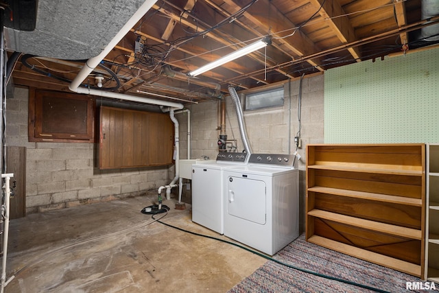 clothes washing area featuring a sink, laundry area, and washer and clothes dryer