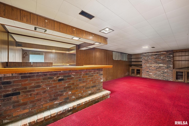 bar featuring visible vents, carpet floors, brick wall, wood walls, and a dry bar