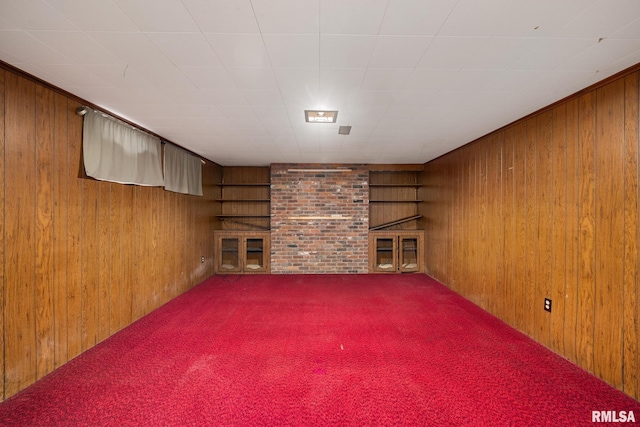 finished basement with carpet flooring, a fireplace, and wood walls