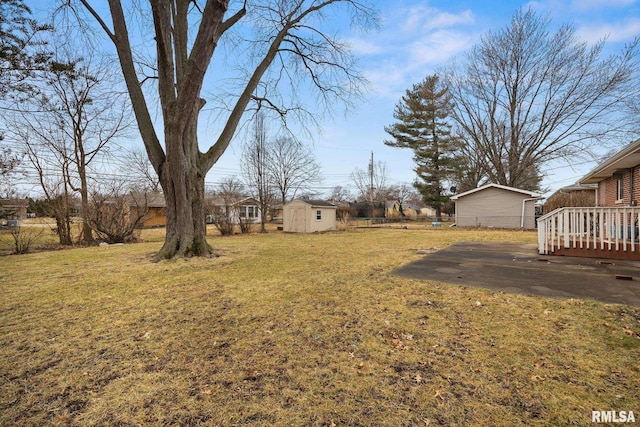 view of yard with a storage shed, an outdoor structure, and fence