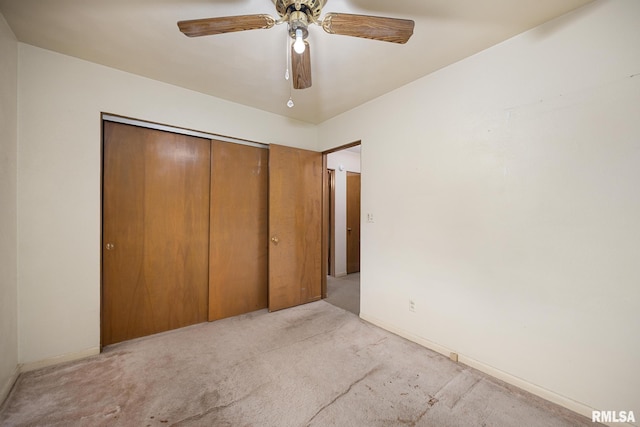 unfurnished bedroom with a ceiling fan, light colored carpet, a closet, and baseboards