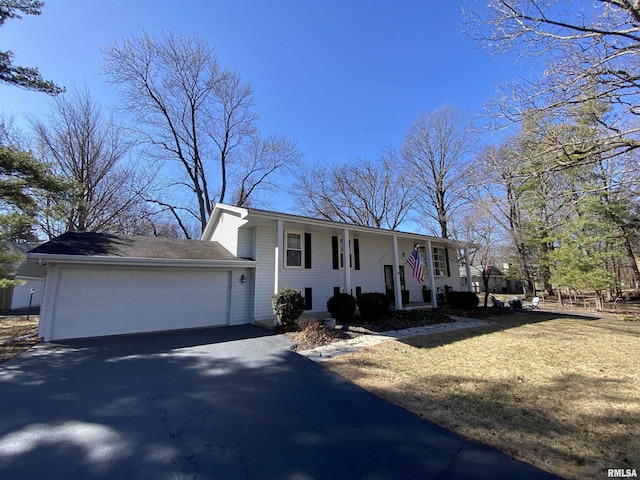 split foyer home with aphalt driveway, a garage, and a front yard