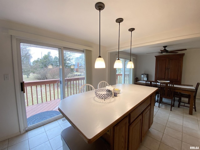 kitchen featuring hanging light fixtures, plenty of natural light, light tile patterned flooring, and a kitchen island