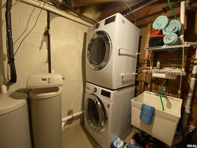 laundry room featuring a sink, stacked washer / drying machine, and laundry area