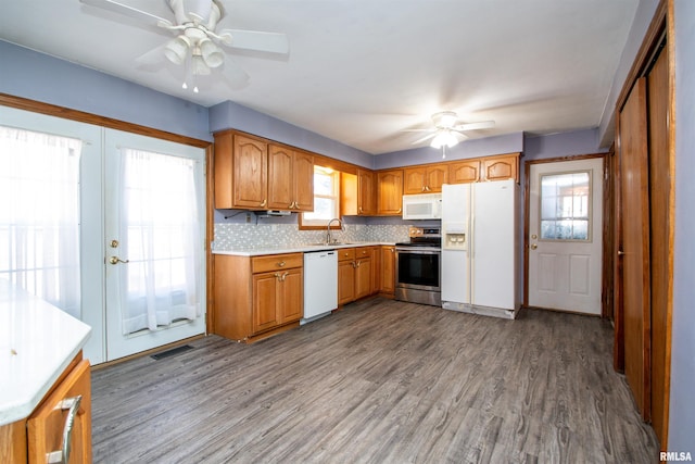 kitchen with visible vents, white appliances, wood finished floors, and a ceiling fan