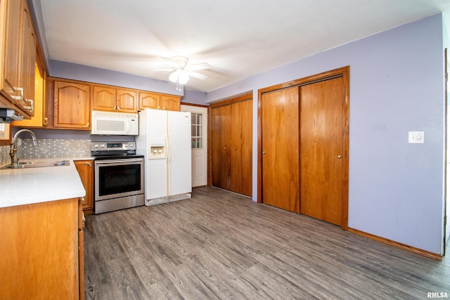 kitchen featuring ceiling fan, light countertops, wood finished floors, white appliances, and a sink