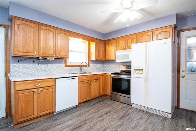 kitchen with white appliances, wood finished floors, a sink, light countertops, and backsplash