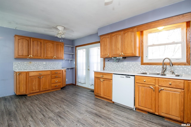 kitchen featuring wood finished floors, a sink, light countertops, dishwasher, and brown cabinets