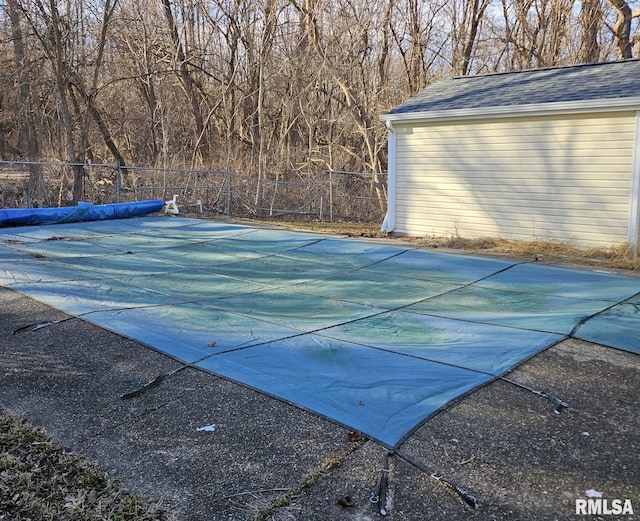 view of swimming pool featuring fence