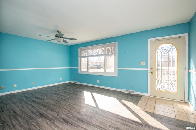 foyer featuring visible vents, ceiling fan, baseboards, and wood finished floors