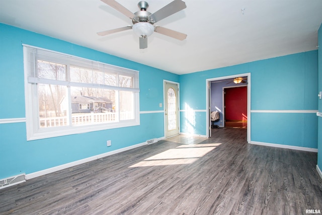 spare room featuring visible vents, baseboards, wood finished floors, and a ceiling fan