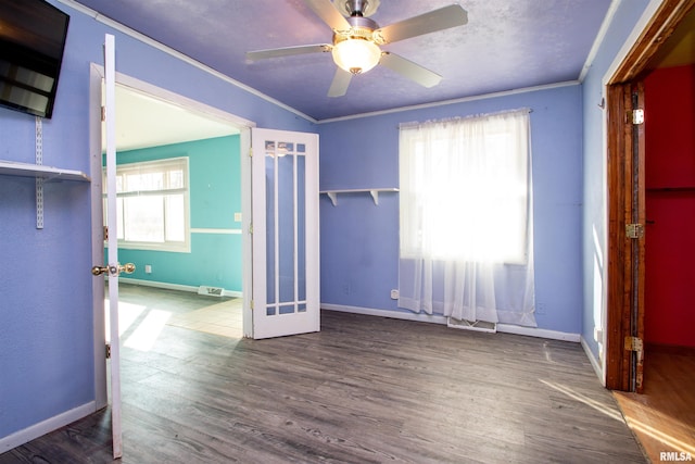 unfurnished bedroom with visible vents, wood finished floors, baseboards, and ornamental molding