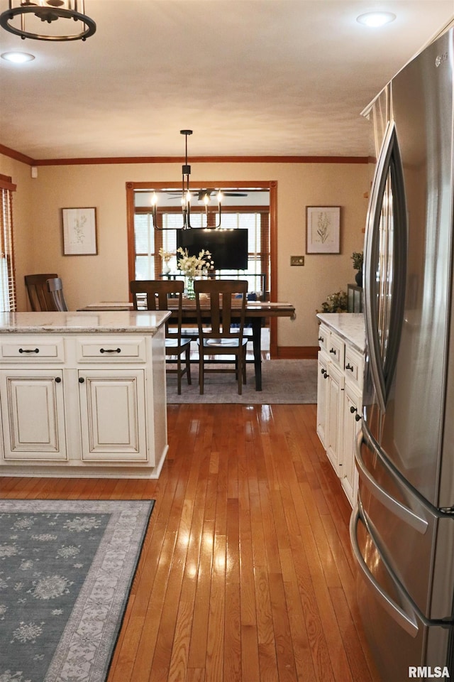 kitchen featuring crown molding, pendant lighting, freestanding refrigerator, and hardwood / wood-style floors