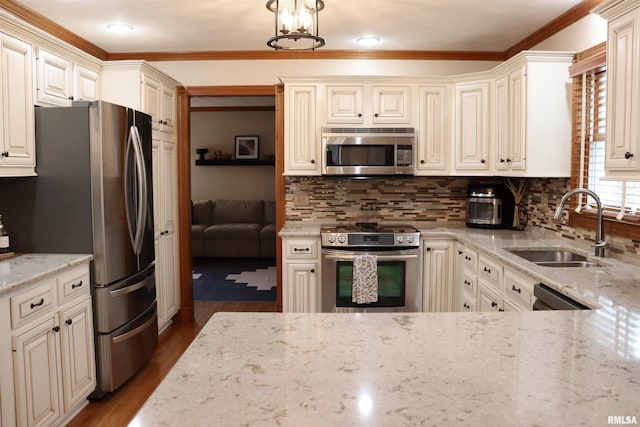 kitchen with a sink, light stone counters, wood finished floors, stainless steel appliances, and decorative backsplash