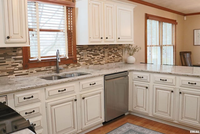 kitchen featuring a sink, stainless steel dishwasher, crown molding, light wood-type flooring, and backsplash