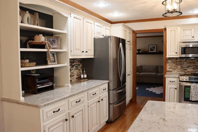 kitchen with light stone counters, wood finished floors, tasteful backsplash, and appliances with stainless steel finishes