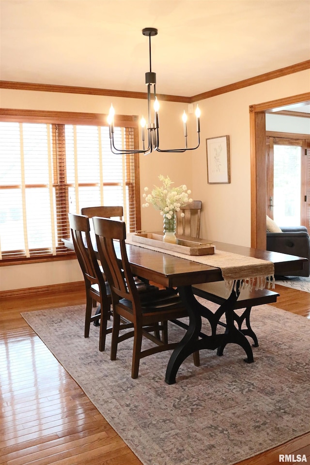 dining space featuring a healthy amount of sunlight, ornamental molding, and wood finished floors