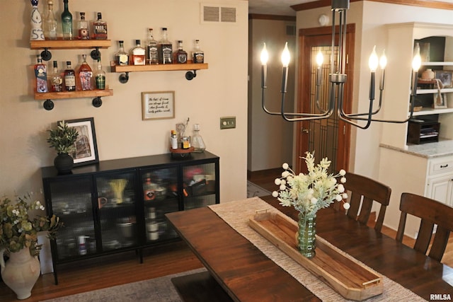 dining space with visible vents, a dry bar, and wood finished floors