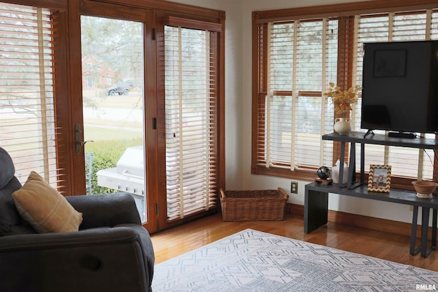 doorway to outside with baseboards and wood finished floors