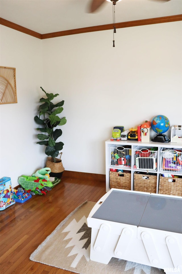 game room with wood finished floors, baseboards, and ornamental molding