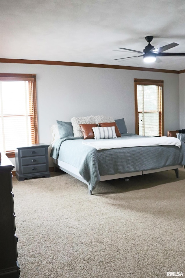 carpeted bedroom featuring a ceiling fan and ornamental molding