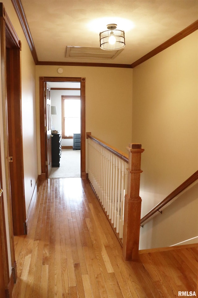 hall featuring wood finished floors, an upstairs landing, baseboards, and ornamental molding