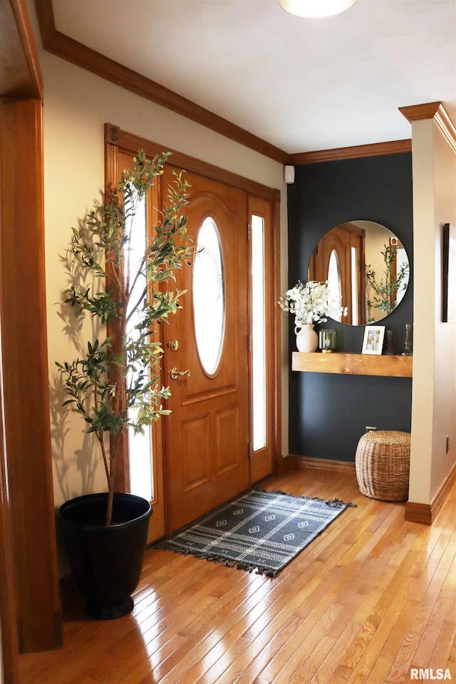 foyer entrance with baseboards, crown molding, and hardwood / wood-style flooring