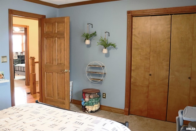 carpeted bedroom featuring a closet, baseboards, and ornamental molding