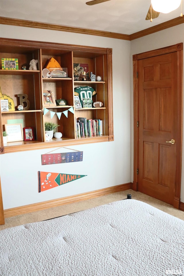 interior space featuring ornamental molding, baseboards, carpet floors, and ceiling fan