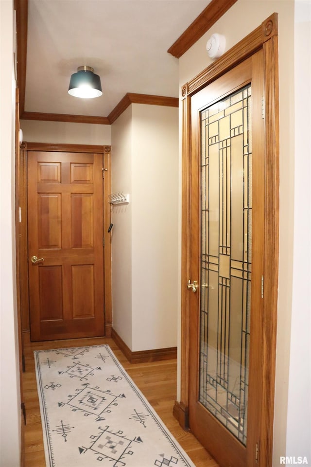 foyer featuring wood finished floors, baseboards, and ornamental molding